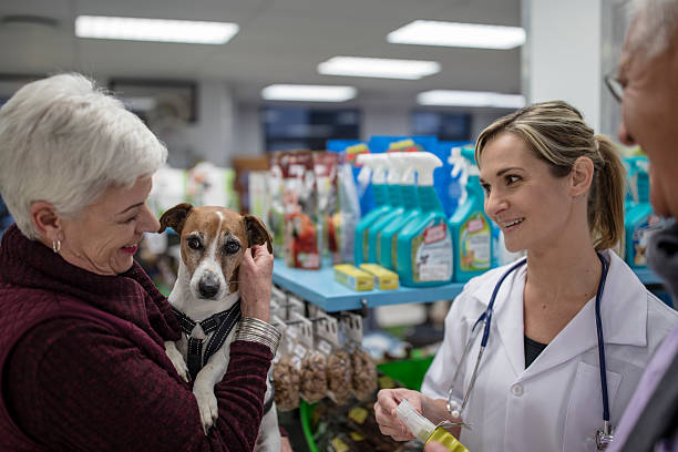 Kucağında köpeği olan yaşlı bir bayan veterinerden tavsiyeler dinliyor.
