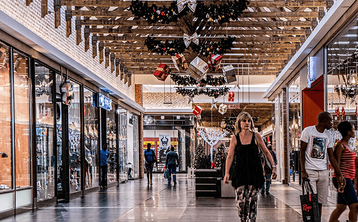 Alışveriş merkezinin koridorunda yürüyen insanlar